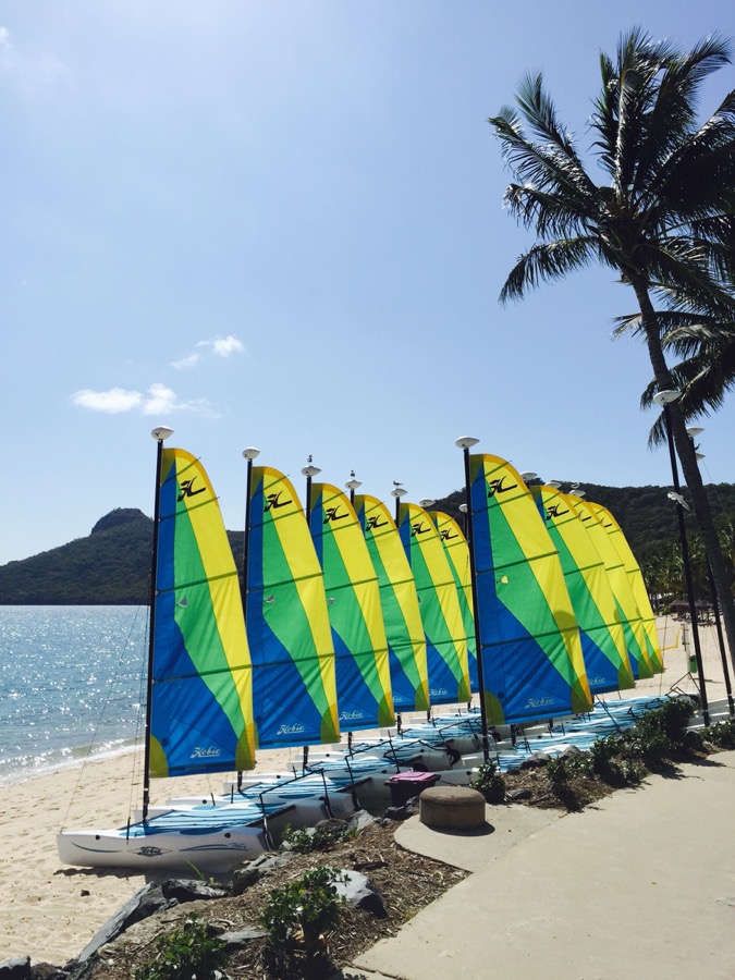 Bright island beach with small sailing boats